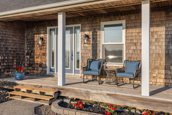 Up close view of front entry and porch seating area. St. Andrews Beach House. Main Residence. Waterfront property for sale.